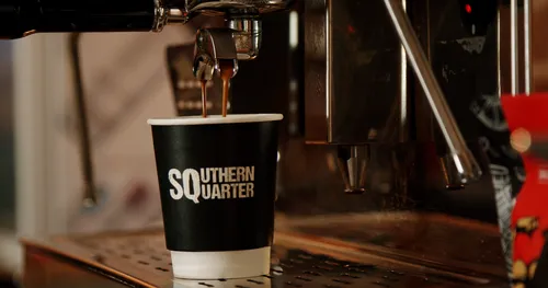 A canonball coffee cup underneath a coffee machine