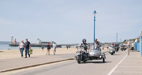 Distinguished Gentlemen's Ride Tricycle driving along Bournemouth beach