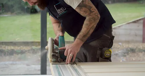 A man cutting word with a bench saw