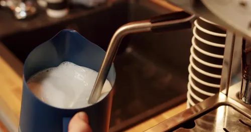 Milk being frothed by a barista